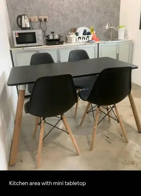 a kitchen area with a black table and two chairs at Pillow Talk 3 Hours Room in Bukit Mertajam