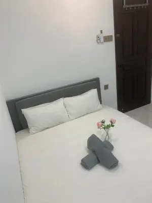 a bed with two stuffed animals and flowers on it at Pillow Talk 3 Hours Room in Bukit Mertajam