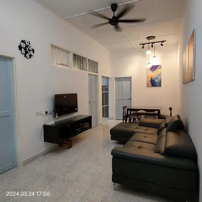 a living room with a couch and a tv at Sterling Homestay in Tanjung Bungah