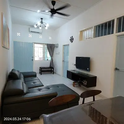 a living room with a couch and a tv at Sterling Homestay in Tanjung Bungah