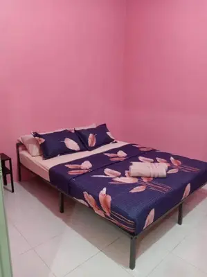 a bed in a room with a pink wall at Bota TheDaun Homestay Taman Indera in Kampung Bota Kiri