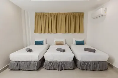two beds in a room with white walls at Villa55 w Private swimming pool BBQ Pool table 25pax in Bayan Lepas