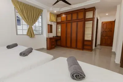 a bedroom with two beds and a bathroom at Villa55 w Private swimming pool BBQ Pool table 25pax in Bayan Lepas