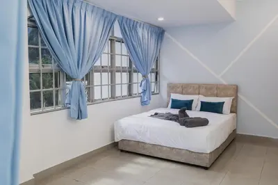 a bedroom with a bed with blue drapes at Villa55 w Private swimming pool BBQ Pool table 25pax in Bayan Lepas