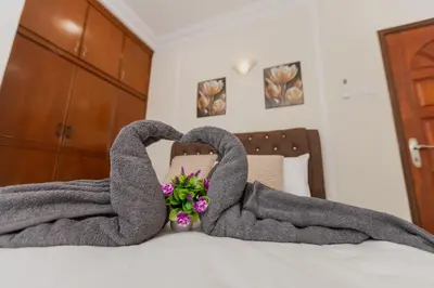 a blanket on top of a bed with flowers at Villa55 w Private swimming pool BBQ Pool table 25pax in Bayan Lepas