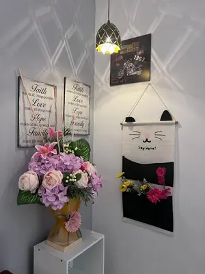 a vase of flowers and a picture of a cat on a wall at \u73ed\u53f0\u6c11\u5bbfNo 29 in Pantai Remis