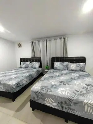 two beds sitting next to each other in a bedroom at \u73ed\u53f0\u6c11\u5bbfNo 29 in Pantai Remis