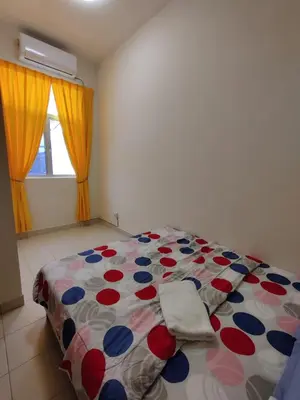 a bedroom with a bed with a colorful comforter at Homestay Adleya in Bagan Serai