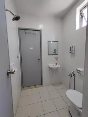 a white bathroom with a toilet and a sink at Homestay Adleya in Bagan Serai