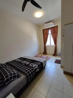 a bedroom with a bed and a ceiling fan at Homestay Adleya in Bagan Serai