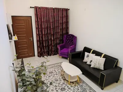 a living room with a black couch and a purple chair at Orked Homestay Seri Iskandar in Seri Iskandar