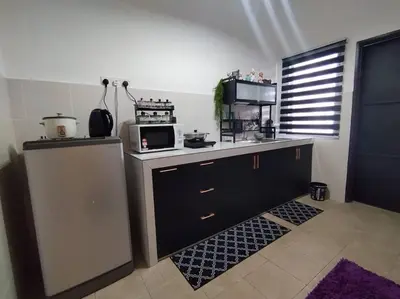 a kitchen with a counter top with a microwave at Orked Homestay Seri Iskandar in Seri Iskandar