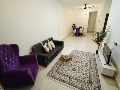a living room with two purple chairs and a rug at Orked Homestay Seri Iskandar in Seri Iskandar
