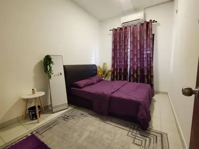 a bedroom with a purple bed in a room at Orked Homestay Seri Iskandar in Seri Iskandar