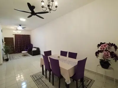 a dining room with a table and purple chairs at Orked Homestay Seri Iskandar in Seri Iskandar