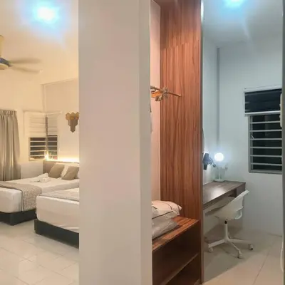 a bedroom with a bed and a desk in a room at Taiping Holiday Home 2 in Taiping