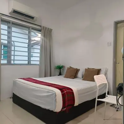 a large bed in a white room with a window at Taiping Holiday Home 2 in Taiping
