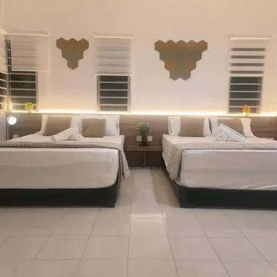 two beds in a room with white floors and windows at Taiping Holiday Home 2 in Taiping