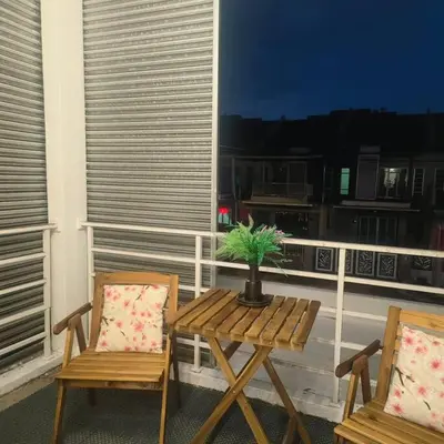 a wooden table and two chairs on a balcony at Taiping Holiday Home 2 in Taiping