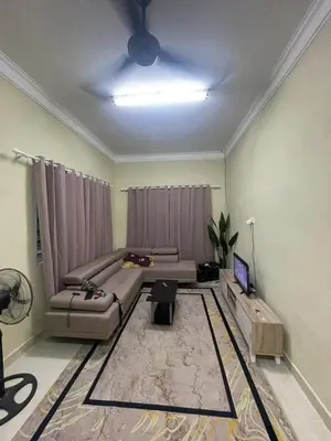 a living room with a couch and a tv at Homestay Abah At in Baling