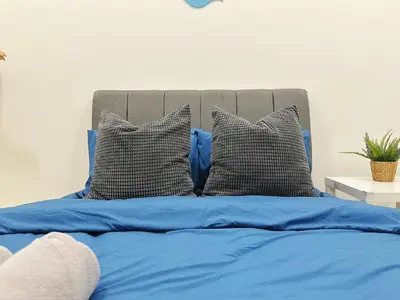 a bed with blue sheets and two pillows at BM\u5927\u5c71\u811a Double Storey Terrace Autocity Alma Aeon Jusco Nearby in Bukit Mertajam