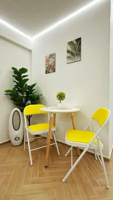 a table and two yellow chairs in a room at Noordin ClanJetties Komtar Heritage Studio - W in George Town