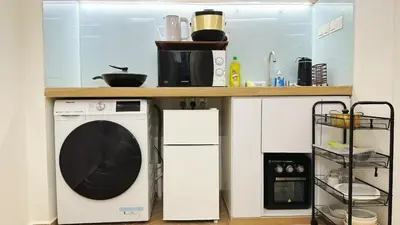 a kitchen with a washing machine under a counter at Noordin ClanJetties Komtar Heritage Studio - W in George Town