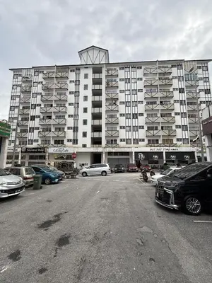 a large building with cars parked in a parking lot at Ayaan Cozy Homestay Cameron Highland in Tanah Rata
