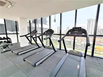 a gym with several tread machines in a building at 2 Rooms Apartment, 4 to 5 pax at Urban Suites by SuperStay in Jelutong