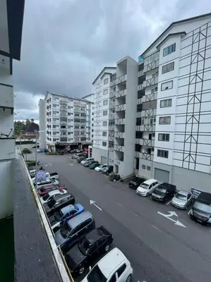 a parking lot with cars parked next to tall buildings at AYAAN FAMILY HOMESTAY FREE WiFi in Tanah Rata