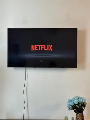 a television on a wall with a netflix sign on it at AYAAN FAMILY HOMESTAY FREE WiFi in Tanah Rata