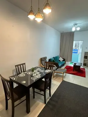 a dining room with a table and chairs and a living room at AYAAN FAMILY HOMESTAY FREE WiFi in Tanah Rata