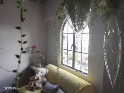 a teddy bear sitting on a couch in front of a window at Cozy 2-Bedroom Apartment in Air Itam, Perfect for Family & Friends Getaway in Ayer Itam