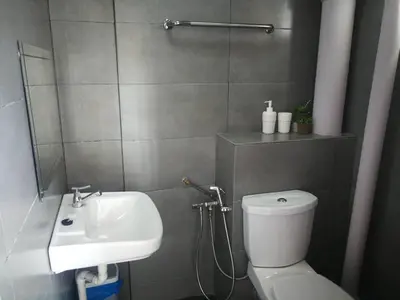 a bathroom with a white toilet and a sink at Cozy 2-Bedroom Apartment in Air Itam, Perfect for Family & Friends Getaway in Ayer Itam
