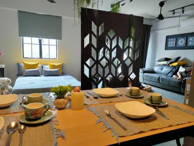 a living room with a table and a couch at Cozy 2-Bedroom Apartment in Air Itam, Perfect for Family & Friends Getaway in Ayer Itam