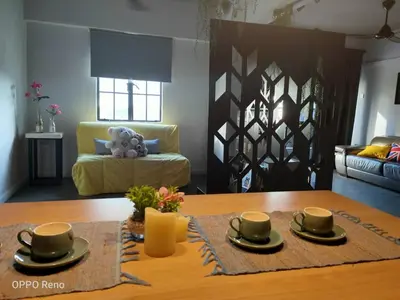 a living room with a table and a couch at Cozy 2-Bedroom Apartment in Air Itam, Perfect for Family & Friends Getaway in Ayer Itam