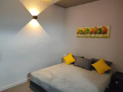 a bedroom with a bed with yellow and gray pillows at Cozy 2-Bedroom Apartment in Air Itam, Perfect for Family & Friends Getaway in Ayer Itam