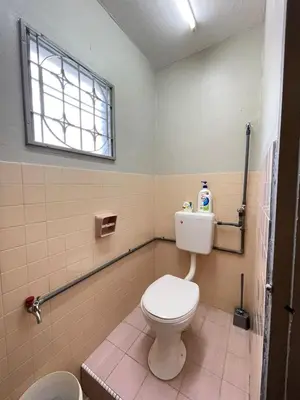 a bathroom with a white toilet and a window at 3 rooms Town Homestay 1 mins to Town in Teluk Intan