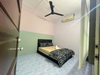 a bedroom with a bed with a ceiling fan at 3 rooms Town Homestay 1 mins to Town in Teluk Intan