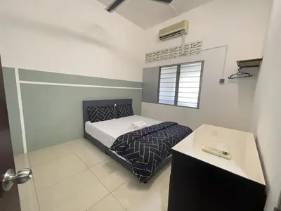 a bedroom with a bed and a desk and a window at 3 rooms Town Homestay 1 mins to Town in Teluk Intan