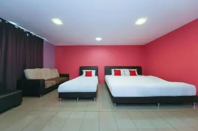 a red room with two beds and a couch at The Inn Hotel in Teluk Intan