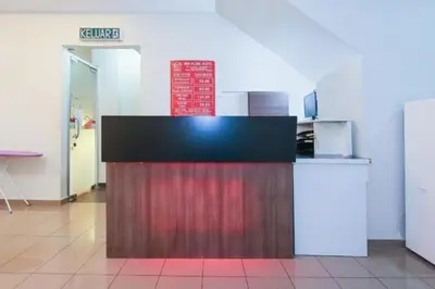 a lobby with a counter and a sign on the wall at The Inn Hotel in Teluk Intan