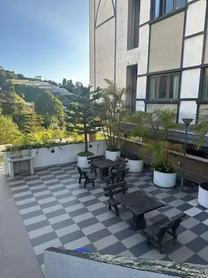 a patio with benches and tables in front of a building at Nova \u5bb6\u5ead\u623f in Brinchang