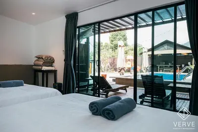 a bedroom with two beds and a view of a pool at Ipoh Cozy 27 Pool Villa 6B5B 30 pax by Verve in Ipoh