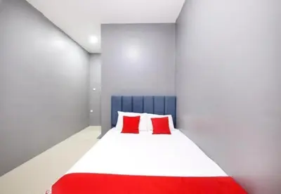 a bedroom with a bed with two red pillows at Hotel Iskandar Perak in Seri Iskandar