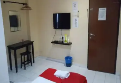 a room with a bed and a desk and a television at Hotel Iskandar Perak in Seri Iskandar