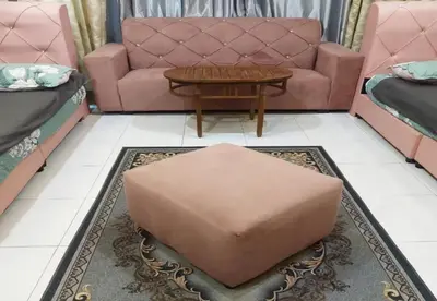 a living room with a couch and a ottoman at Hotel Iskandar Perak in Seri Iskandar