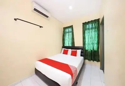 a bedroom with a bed and two windows at Hotel Iskandar Perak in Seri Iskandar