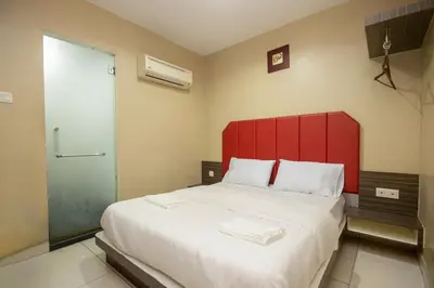 a bedroom with a large bed with a red headboard at JQ Happy Lumut Hotel in Lumut