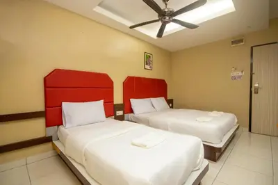 a bedroom with two beds with red headboards at JQ Happy Lumut Hotel in Lumut